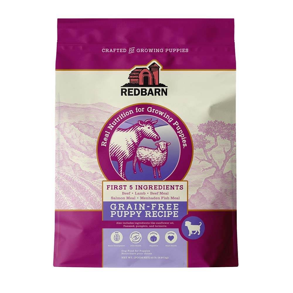 Purple and tan bag of Redbarn Grain Free Puppy Recipe dog food with a cow and lamb on it