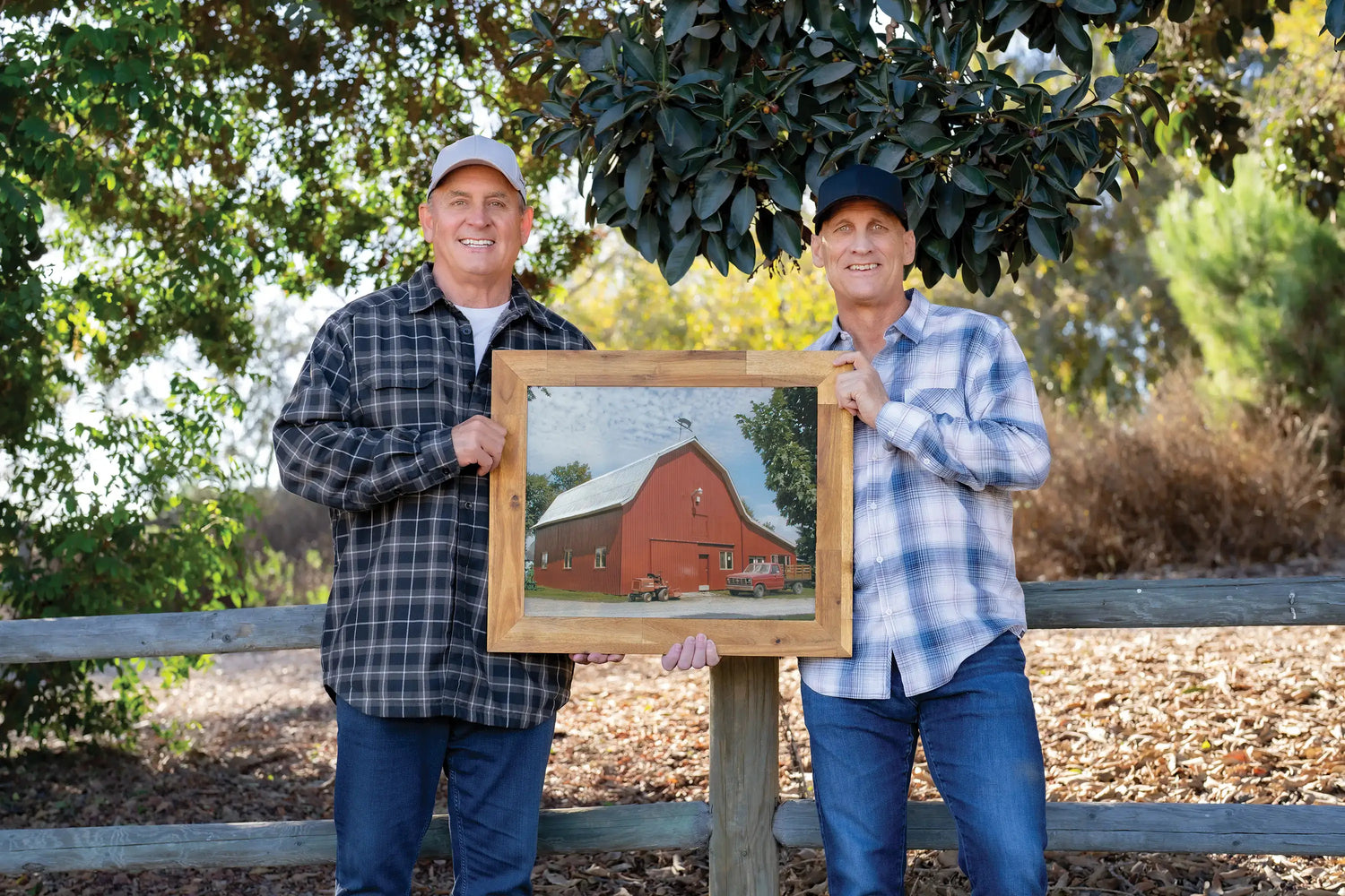 Jeff and Howie holding a framed picture of the original red barn